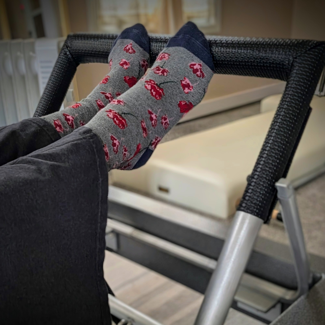 Feet placed on the foot bar of the reformer for Footwork